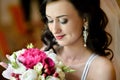 Beauty bride in bridal gown with bouquet and lace veil indoors Royalty Free Stock Photo