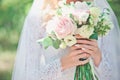 Beauty bride in bridal gown with bouquet and lace veil on the nature. Beautiful model girl in a white wedding dress. Royalty Free Stock Photo