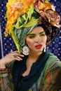 Beauty bright woman with creative make up, many shawls on head like cubian, ethno look closeup Royalty Free Stock Photo