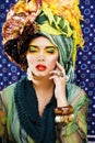 Beauty bright woman with creative make up, many shawls on head like cubian, ethno look closeup Royalty Free Stock Photo