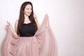 Beauty brunette girl with long hair. Model in a pink dress, flying dress, fabric. Pink makeup, style, fashion, beauty photo, soap Royalty Free Stock Photo