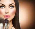 Beauty brunette girl with makeup brushes Royalty Free Stock Photo