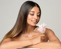 Beauty Brunette Model with Long Silk Shiny Hairstyle. Beautiful Woman looking at Flower relaxing in Spa Massage Salon. Women Face Royalty Free Stock Photo