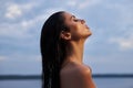 Beauty brunette woman in a black dress poses in a sea lake against a blue sky background. Long hair sexy woman and beautiful Royalty Free Stock Photo