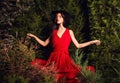 Beauty brunette women in red dress & hat pose at night park. Royalty Free Stock Photo