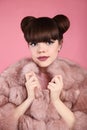 Beauty bun hairstyle. Fashion teen girl model in pink fur coat.