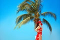 Beauty Carefree young girl with red hat relaxing on tropical beach with exotic Palm tree. Summer outdoor portrait. Lifestyle. Royalty Free Stock Photo