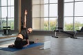 Beauty caucasion white woman practicing yoga near window in yoga studio. Young beautiful girl wearing sportswear doing exercises Royalty Free Stock Photo