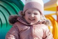 Beauty child . happy child on a swing on a sunny spring day. Happy baby girl in a pink hat and scarf laughs Royalty Free Stock Photo