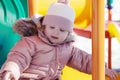 Beauty child . happy child on a swing on a sunny spring day. Happy baby girl in a pink hat and scarf laughs Royalty Free Stock Photo