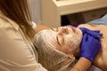 Beauty Clinic.woman gets a professional facial procedure. Beautician makes massage on a woman's face. face renewal Royalty Free Stock Photo