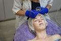 Beauty Clinic.woman gets a professional facial procedure. Beautician makes massage on a woman`s face. face renewal Royalty Free Stock Photo