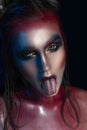 Beauty close-up portrait of beautiful impudent woman showing tongue, model face with magic creative fashion multicolored make-up. Royalty Free Stock Photo