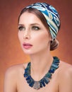 Beauty closeup portrait of beautiful young woman in a headscarf. Necklace on her neck Royalty Free Stock Photo