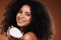 Beauty, coconut and woman skincare or hair care with happy smile or curls for natural oil and brown studio background