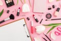 Beauty composition with clipboard, tulips flowers, cosmetics and accessory on pink background. Top view. Flat lay. Home feminine d