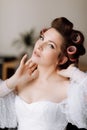 beauty concept. portrait of a beautiful young showy brunette woman with bright pin-up make-up in pink curlers. Studio