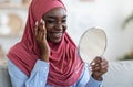 Beauty Concept. Pretty Black Muslim Woman In Hijab Looking In Magnifying Mirror Royalty Free Stock Photo