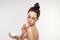 Beauty Concept. Woman Applying  Cosmetics Cream, Spreads it on her shoulder  to moisturize her skin and Smiling. Royalty Free Stock Photo