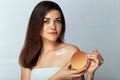 Beauty Concept. Woman Holds a Cosmetic Cream in her Hand and Spreads it on Her Shoulder  to Moisturize her Skin. Female Applying C Royalty Free Stock Photo