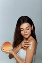 Beauty Concept. Woman holds a cosmetic crem in her hand and spreads it on her shoulder to moisturize her skin. Female Applying Cre Royalty Free Stock Photo