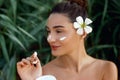 Beauty Concept. woman holds a moisturizer in her hand and spreads it on her face to moisturize her skin and wrinkle from impuritie Royalty Free Stock Photo