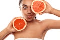 Beauty Concept. Young african woman isolated on white covering eye with grapefruit pouting lips silly close-up Royalty Free Stock Photo