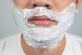 Beauty concepts for health and skin care an Asian guy with a mustache with a beard with a bubble on his face, preparing to shave