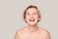 Beauty Conept. Mature woman standing isolated on grey close-up laughing cheerful Royalty Free Stock Photo