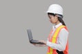 Beauty confident young Asian worker with safty equipment carrying laptop on gray isolated background