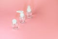 Beauty cosmetics glassbottle; branding mock up; front view on pastel pink background. Royalty Free Stock Photo