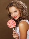 Beauty curly girl portrait holding colorful lollipop. Royalty Free Stock Photo