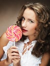 Beauty curly girl portrait holding colorful lollipop. Royalty Free Stock Photo