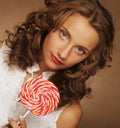 Beauty curly girl portrait holding colorful lollipop. Royalty Free Stock Photo