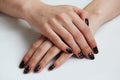 beauty delicate coffee manicure with gold sparkles with gel varnish on a white wall background Royalty Free Stock Photo