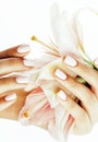 Beauty delicate hands with manicure holding flower lily close up isolated on white, spa salon concept Royalty Free Stock Photo