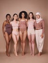 Beauty, diversity and body positivity with a woman friends together in studio on a brown background for inclusion