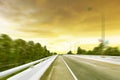 Beauty empty highway road with lamp post and tree on golden sunset motion blur background Royalty Free Stock Photo