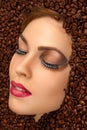 Beauty face with bright makeup in coffee beans Royalty Free Stock Photo
