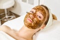 Beauty Face Care. Portrait Of Attractive Young Woman Putting Scrub On Facial Skin. Close up Beautiful Female Exfoliating