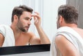 Beauty face portrait of a beautiful man applying face cream. Skincare cream for man. Mask, skin lifting and anti-aging Royalty Free Stock Photo