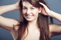 Beauty, face and smile portrait of a woman in studio with hands in hair, makeup and cosmetics. Headshot of a happy young