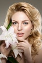 Beauty face woman, flowers, lily. Girl healthy model in spa salon. Cream treatment products. Facial skin terapy Royalty Free Stock Photo