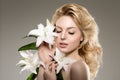 Beauty face woman, flowers, lily. Girl healthy model in spa salon. Cream treatment products. Facial skin terapy Royalty Free Stock Photo