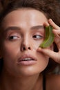 Beauty Face. Woman Holding Slices Of Fresh Juicy Aloe Vera Leaf At Her Face Royalty Free Stock Photo