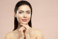 Beauty Face Woman Portrait. Healthy Skin Care and Make up. Girl with Hands under Chin with Gloss Makeup over Beige Background Royalty Free Stock Photo