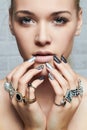 Beauty face.woman`s hands with jewelry rings