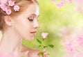 Beauty face of young beautiful woman with pink flowers in her ha Royalty Free Stock Photo