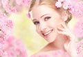 Beauty face of young happy beautiful woman with pink flowers in Royalty Free Stock Photo