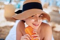 Beauty Facial Care. Young  Female Holding Bottle Sun Cream and  Applying on Face Smiling. Beauty Face. Royalty Free Stock Photo